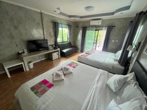 南府ชิดชายชล รีสอร์ท น่าน的酒店客房设有两张床和电视。