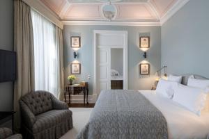 SantarValverde Santar Hotel & SPA - Relais & Châteaux的一间卧室配有一张大床和一把椅子