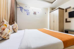 博帕尔FabHotel Shree Regency的一间卧室配有一张床和电视