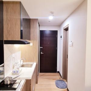 名古屋Apartment in Citra Plaza Nagoya Lubuk Baja Kota Batam的厨房设有水槽和棕色的门