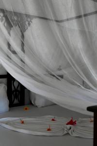 江比阿阿姆卡别墅的一张白色的床,上面有红色的鲜花