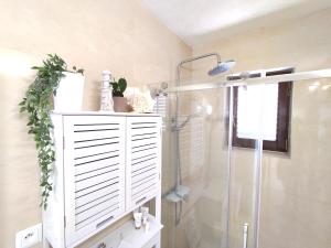 苏提万Apartmán BRAĆKI CVIJET的带淋浴的浴室和白色橱柜。