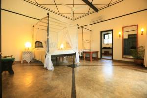 马拉维拉霍拉萨泊拉酒店的一间卧室,卧室内配有一张天蓬床