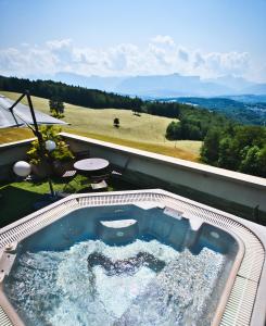 克吕塞耶Château des Avenieres - Relais & Châteaux的阳台上的按摩浴缸享有高空美景。