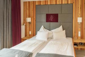 拉姆绍达赫斯坦拉森霍夫酒店的一间卧室配有两张带白色枕头的床
