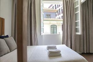 波尔图Oporto Sweet Downtown 5的一间卧室配有一张床,上面有两条毛巾