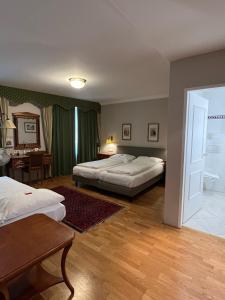 韦尔斯戈瑟布劳酒店的一间卧室配有两张床、一张桌子和一张书桌