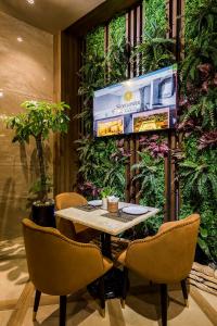 胡志明市Sunflower Luxury Hotel的植物间里的桌椅
