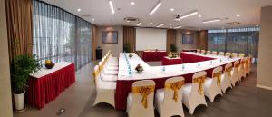 河内My Way Hotel & Residence Ha Noi的一张长桌子,配有红白的桌子和椅子