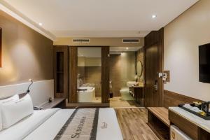 胡志明市Sunflower Luxury Hotel的一间酒店客房 - 带一张床和一间浴室