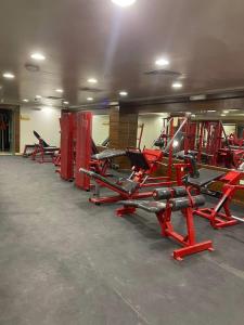 胡富夫البستان للأجنحة الفندقية的健身房里一排红色的椅子