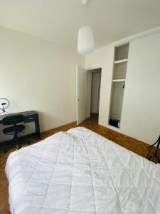 里摩日Appartement T4 Madoumier的卧室配有一张白色大床和一张书桌