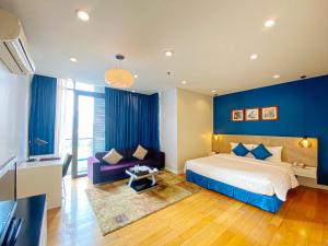 河内My Way Hotel & Residence Ha Noi的卧室拥有蓝色的墙壁,配有一张床和一张沙发