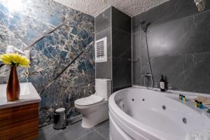 阿瓦诺斯SIGNATURE GARDEN AVANOS Hotel & SPA的浴室配有白色浴缸和卫生间。