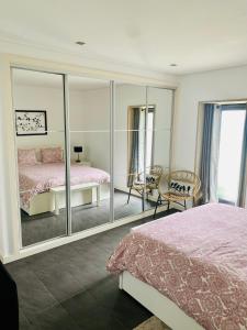 MontariaSerra de Arga Mountain House的一间卧室配有镜子、一张床和一把椅子