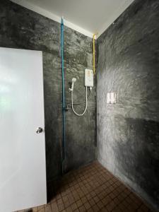 涛岛Koh Tao Little House的一间带淋浴的浴室,墙上装有软管