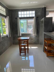 涛岛Koh Tao Little House的一间带桌子和窗户的用餐室