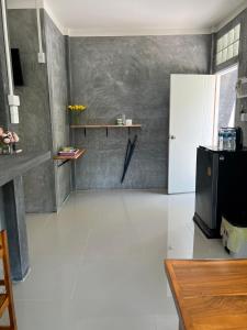 涛岛Koh Tao Little House的一间铺有白色地板并配有冰箱的客厅