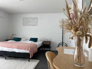 布鲁日Perfect getaway in Bruges!的一间卧室配有一张床和一张花瓶桌子
