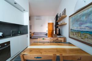 蒙特罗索阿尔马雷Appartamento Piccolo Principe的一间带玻璃桌的用餐室和一间厨房