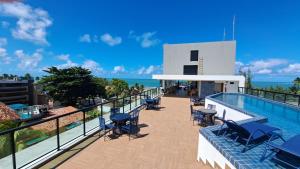 伊波茹卡Apartamento com piscina no Condominio Maraca2的阳台设有游泳池和桌椅。