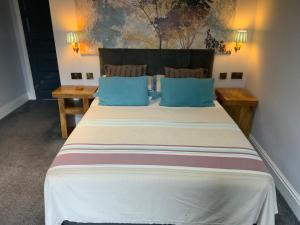 卡斯尔福德Wheldale Hotel的一间卧室配有一张带蓝色枕头的大床