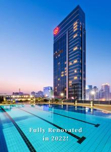 广州Sheraton Guangzhou Hotel的一座高楼前的游泳池