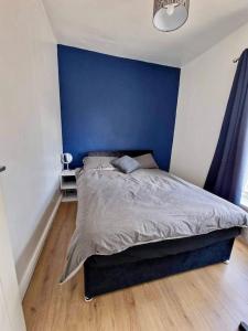 赫尔House near city centre的卧室内的一张床铺,卧室内有蓝色的墙壁