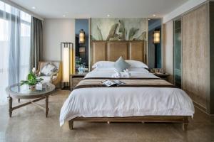 三亚三亚柏瑞精品海景酒店的一间卧室配有一张大床和一张桌子