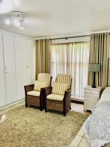 德班维尔10VDW Self Catering Apartments的一间卧室配有两把椅子和一张床