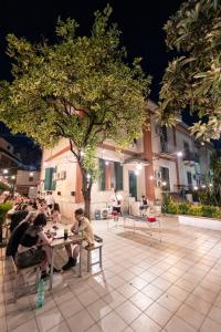 那不勒斯Naples Experience Hostel - Age Limit 18-28的一群坐在树下桌子上的人