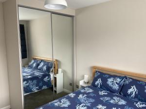 特威克纳姆Large 2-bedroom maisonette with free parking的卧室配有镜子,位于床边