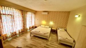 KrumovgradHotel Divna的一间卧室设有两张床和窗户。