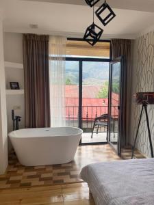 卡兹贝吉Sunny guesthouse的卧室设有浴缸,设有阳台