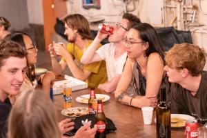 那不勒斯Naples Experience Hostel - Age Limit 18-28的坐在桌边喝啤酒的一群人