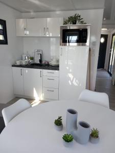 HrdoňovHausboat David的白色的厨房配有白色的桌子和椅子