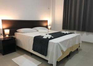 萨利诺波利斯Hotel Vilas的一间卧室配有一张大床,提供黑白毯子