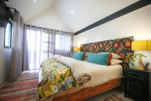 温特和克Droombos的一间卧室配有一张大床和花卉床头板