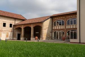 TerruggiaCascina Baronina的前面有绿草的砖砌大建筑