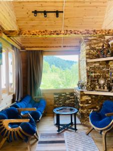 KhuloHouse in The Mountains的客厅设有蓝色的沙发和大窗户