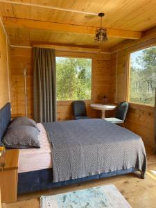 KhuloHouse in The Mountains的一间卧室配有一张床、一张桌子和两把椅子