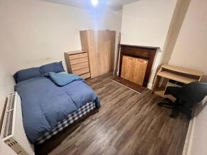 伯明翰Private Rooms with Shared Kitchen & Bathroom - Birmingham的一间卧室配有一张床、一张桌子和一把椅子