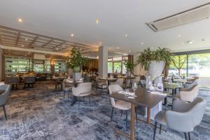 沃尔夫海泽Fletcher Hotel-Restaurant De Buunderkamp的餐厅设有桌椅和窗户。