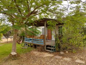 Talmei Yosefביתהבוצ - מקום טבעי למפגשים的一个小房子,有门廊和一棵树
