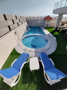 Al BurjSea view的两把蓝白椅子和一个游泳池