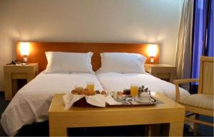 雅典Dorian Inn - Sure Hotel Collection by Best Western的一间酒店客房,配有一张带食物盘的床