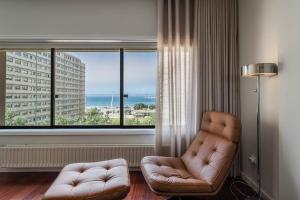 马托西纽什GuestReady - A prime stay near the beach的客厅配有椅子和大窗户