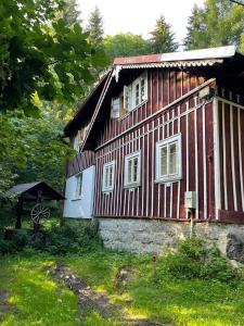 代斯纳Roubenka u potoka Jizerské hory的红白的红色凉爽的房子