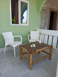 SanyangBosofet Beach and Creek Lodge的门廊上配有咖啡桌和2把白色椅子