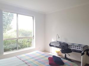 堪培拉Entire 2BR sunny house @Franklin, Canberra的白色的客房设有钢琴和大窗户